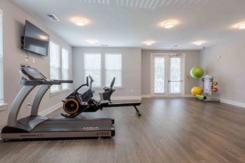 A treadmill and a stationary bike are in a room with a television. at Bulls Creek, Charleston, SC, 29414